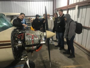Duane Enos shows students the Cessna-150 engine during a required annual inspection.
